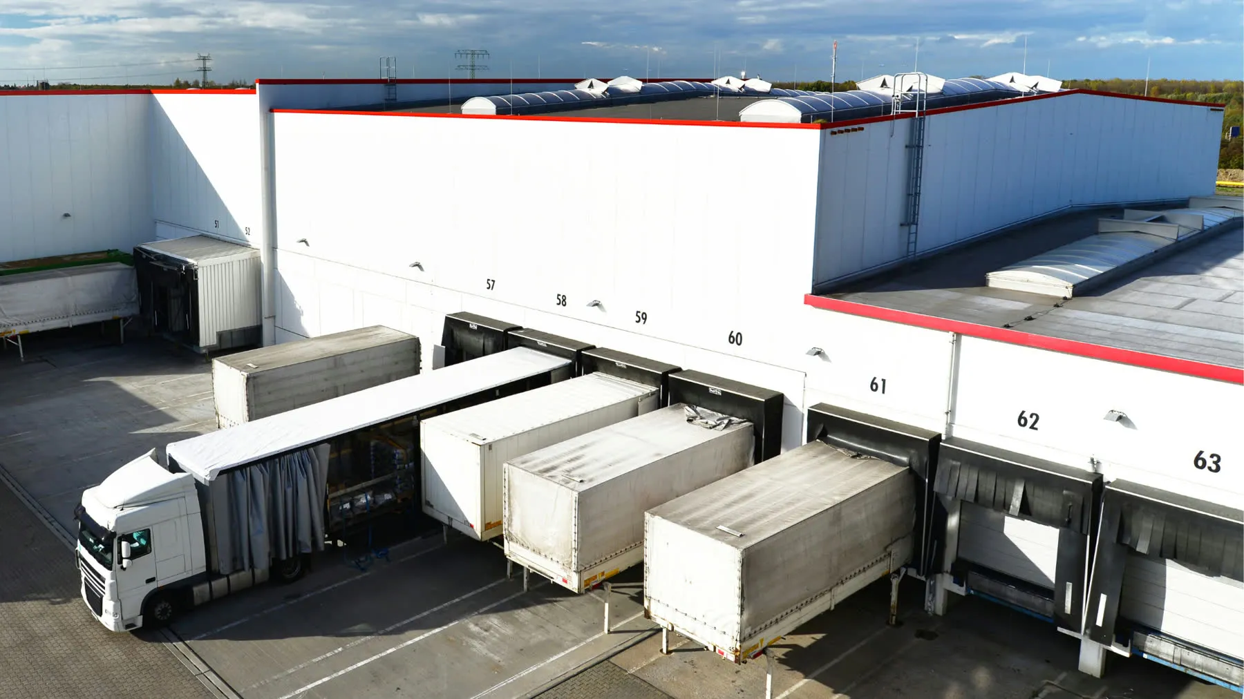 A warehouse loading dock with trucks backed into its numbered bays